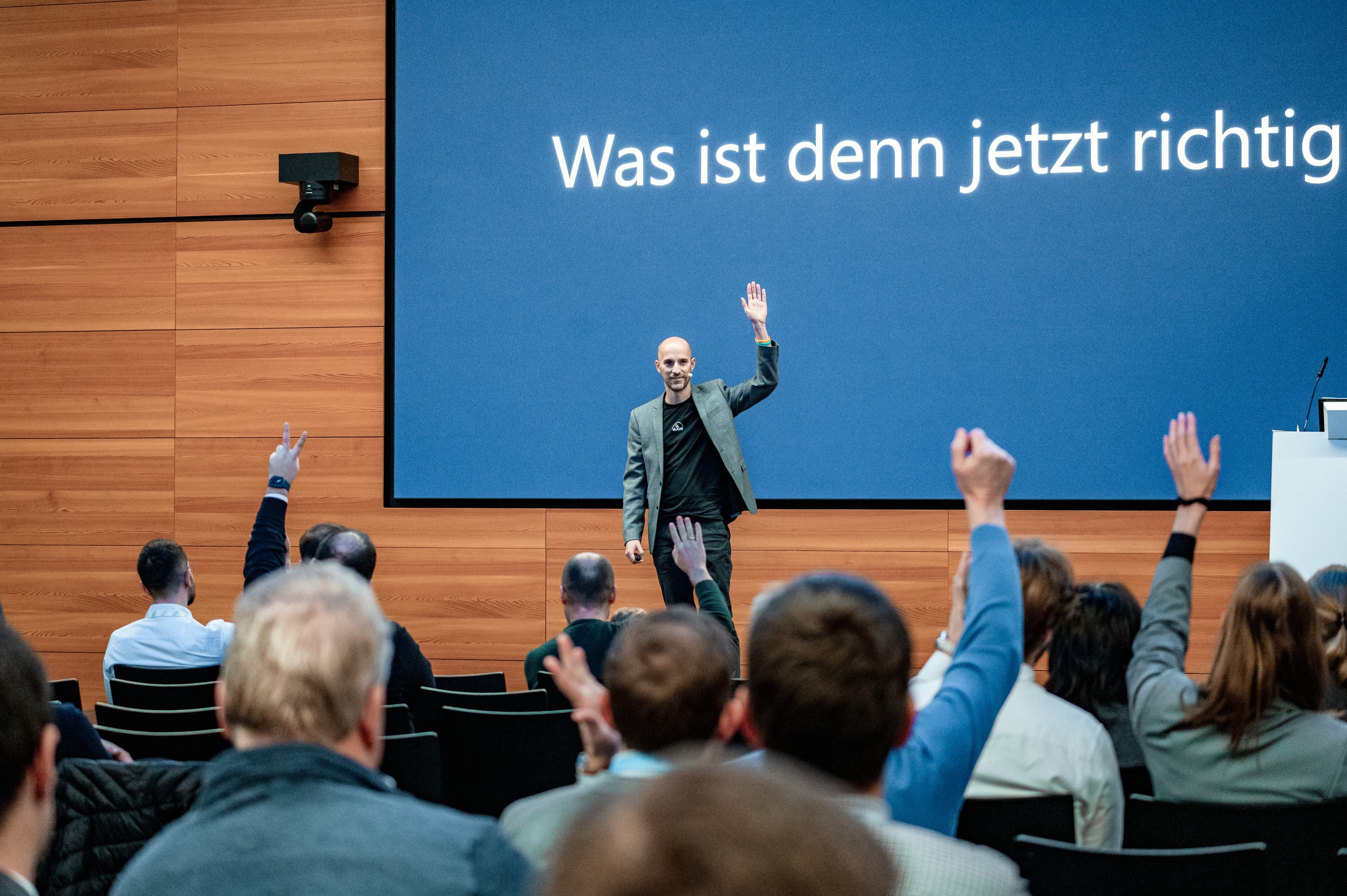 Micha Müller auf der Bühne, das Publikum meldet sich